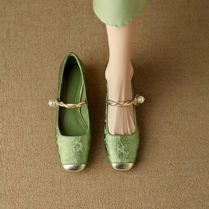 Women's sophisticated Mary Jane flats featuring a shimmering metallic toe and elegant pearl strap.