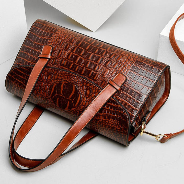 Stylish women's handbag featuring an elegant embossed crocodile print, a luxurious fashion accessory.
