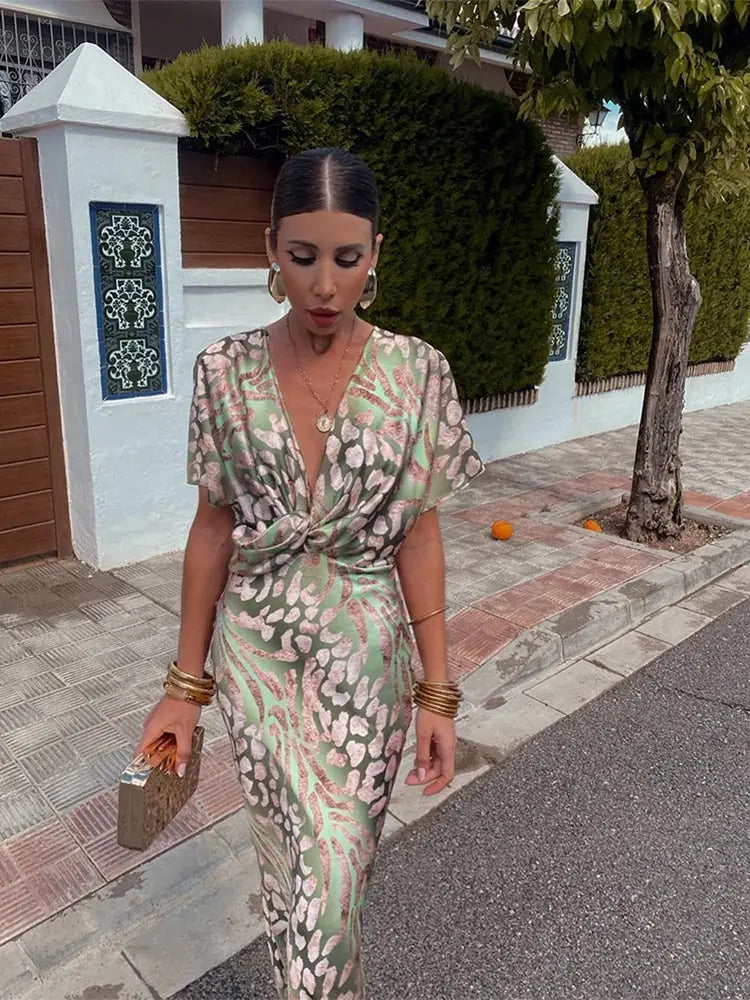 Elegant women's V-neck maxi dress featuring a chic twist front and delicate flutter sleeves.