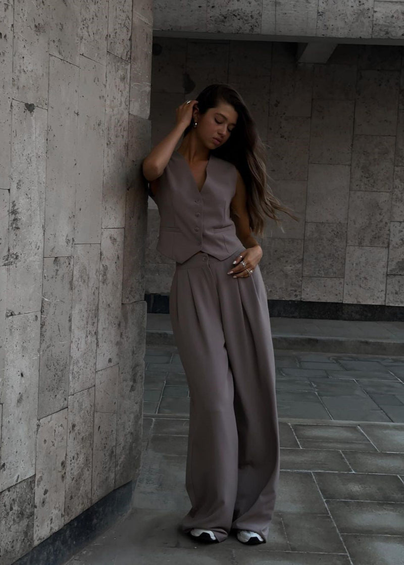 "Elegante set blazer senza maniche e pantaloni slim-fit donna in tessuto leggero, scollo a V, perfetto per occasioni formali.