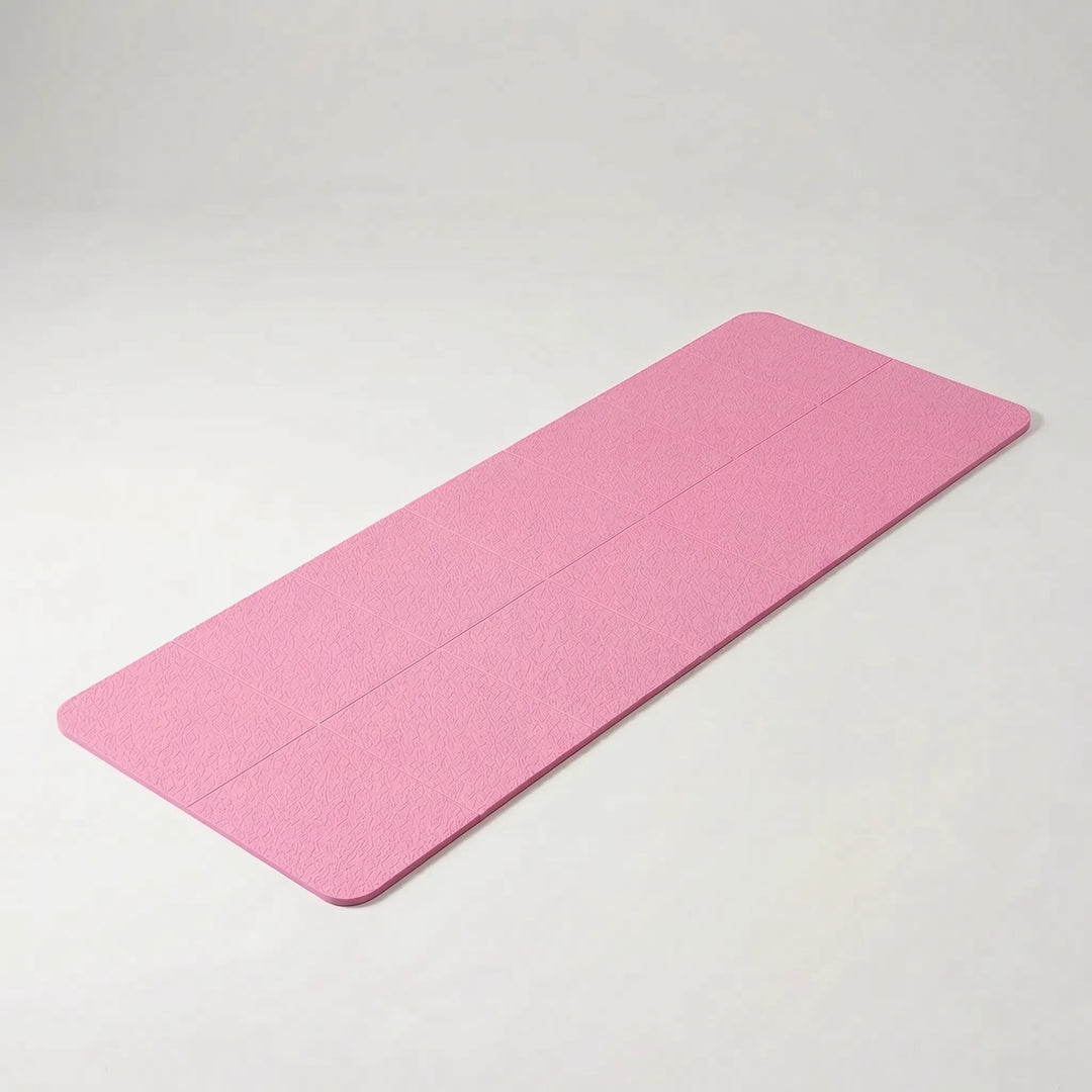 Compact foldable TPE yoga mat for travel. Easy storage & portable for gym, home fitness, & pilates practice.