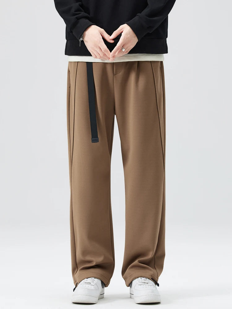 Man sitting comfortably in stylish wide-leg trousers, perfect for modern casual wear.