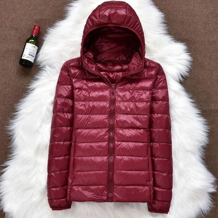 Giacca invernale donna impermeabile con piume d'anatra bianca, pieghe eleganti, colore scuro, stile casual e sofisticato.