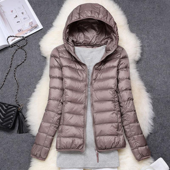Giacca invernale donna impermeabile con piume d'anatra bianca, pieghe eleganti, colore scuro, stile casual e sofisticato.
