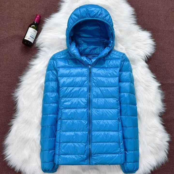 Giacca invernale donna impermeabile con piume d'anatra bianca, pieghe eleganti, colore scuro, stile casual e sofisticato.