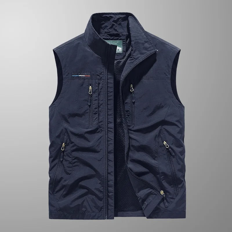"Giubbotto da carico uomo senza maniche, colori vari, tasche con zip, materiale resistente all'acqua e al vento."