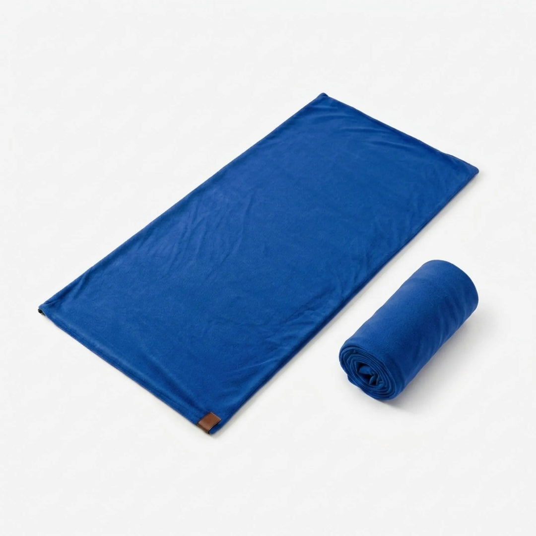 Lightweight green sleeping bag liner, portable camping gear for adventure travel and outdoor sleeping.