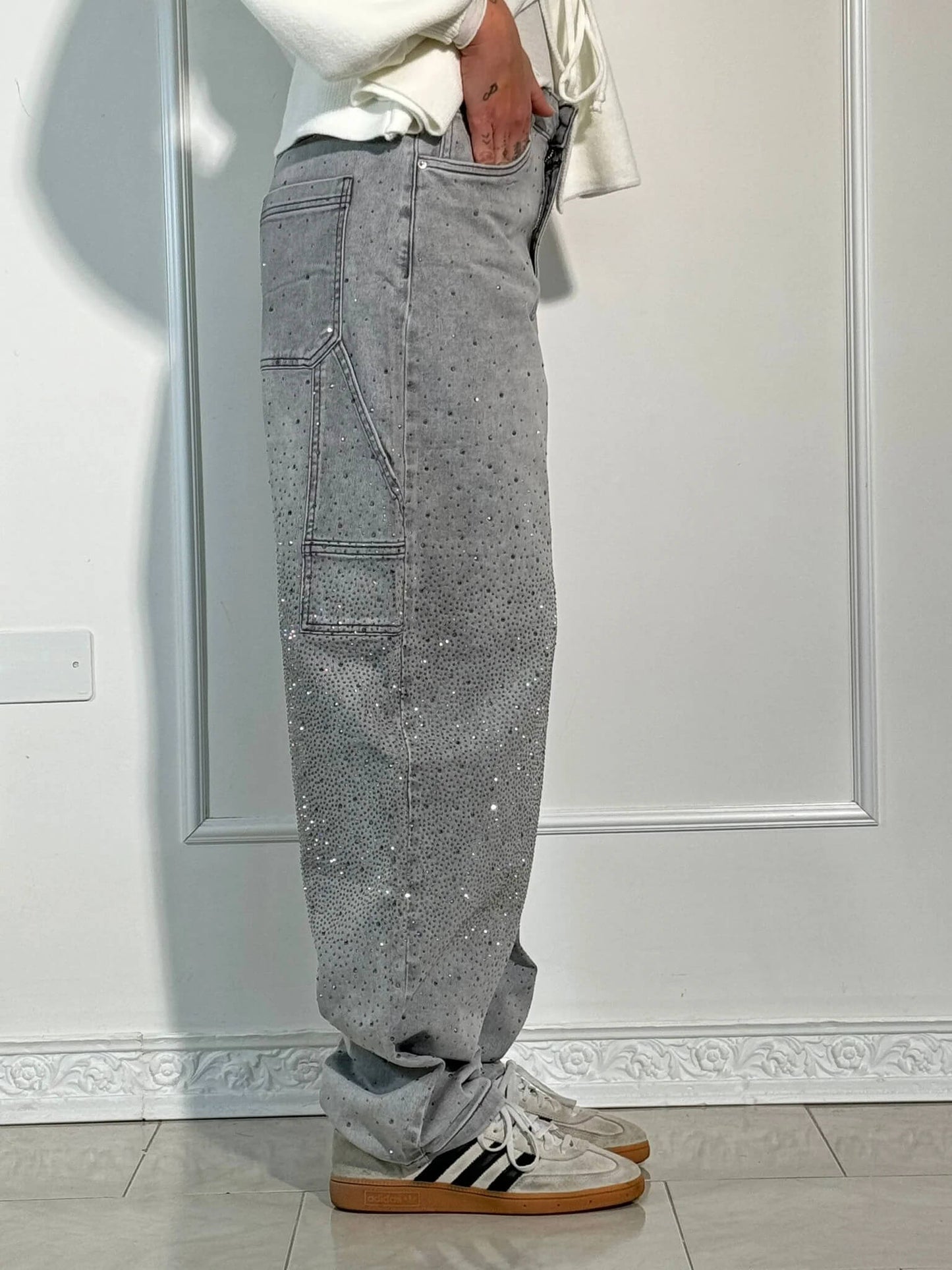 "Jeans donna baggy, dettagli brillanti, denim blu scuro, gambe larghe, chiusura zip e bottone, look casual ed elegante."