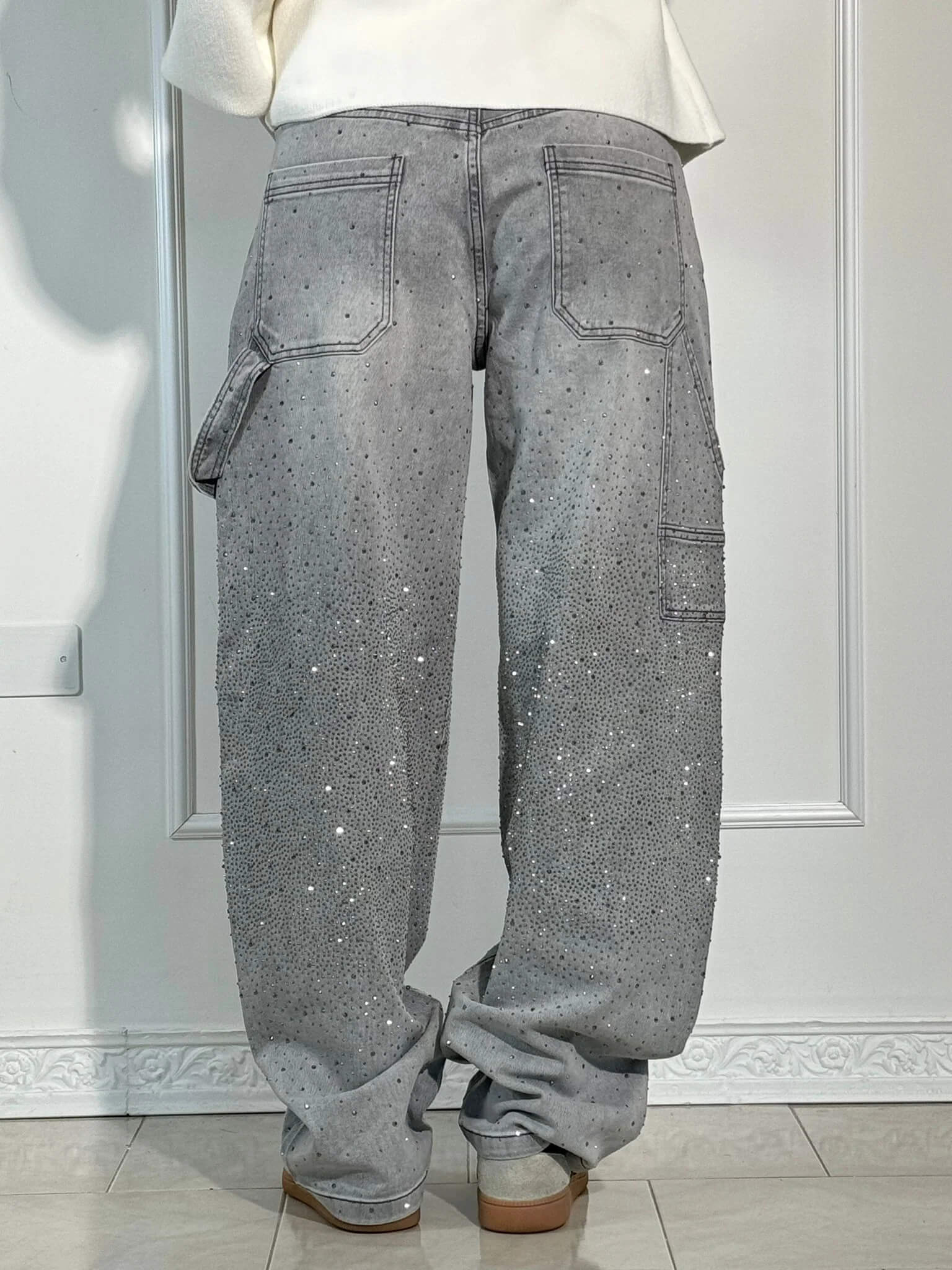 "Jeans donna baggy, dettagli brillanti, denim blu scuro, gambe larghe, chiusura zip e bottone, look casual ed elegante."