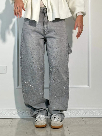 "Jeans donna baggy, dettagli brillanti, denim blu scuro, gambe larghe, chiusura zip e bottone, look casual ed elegante."