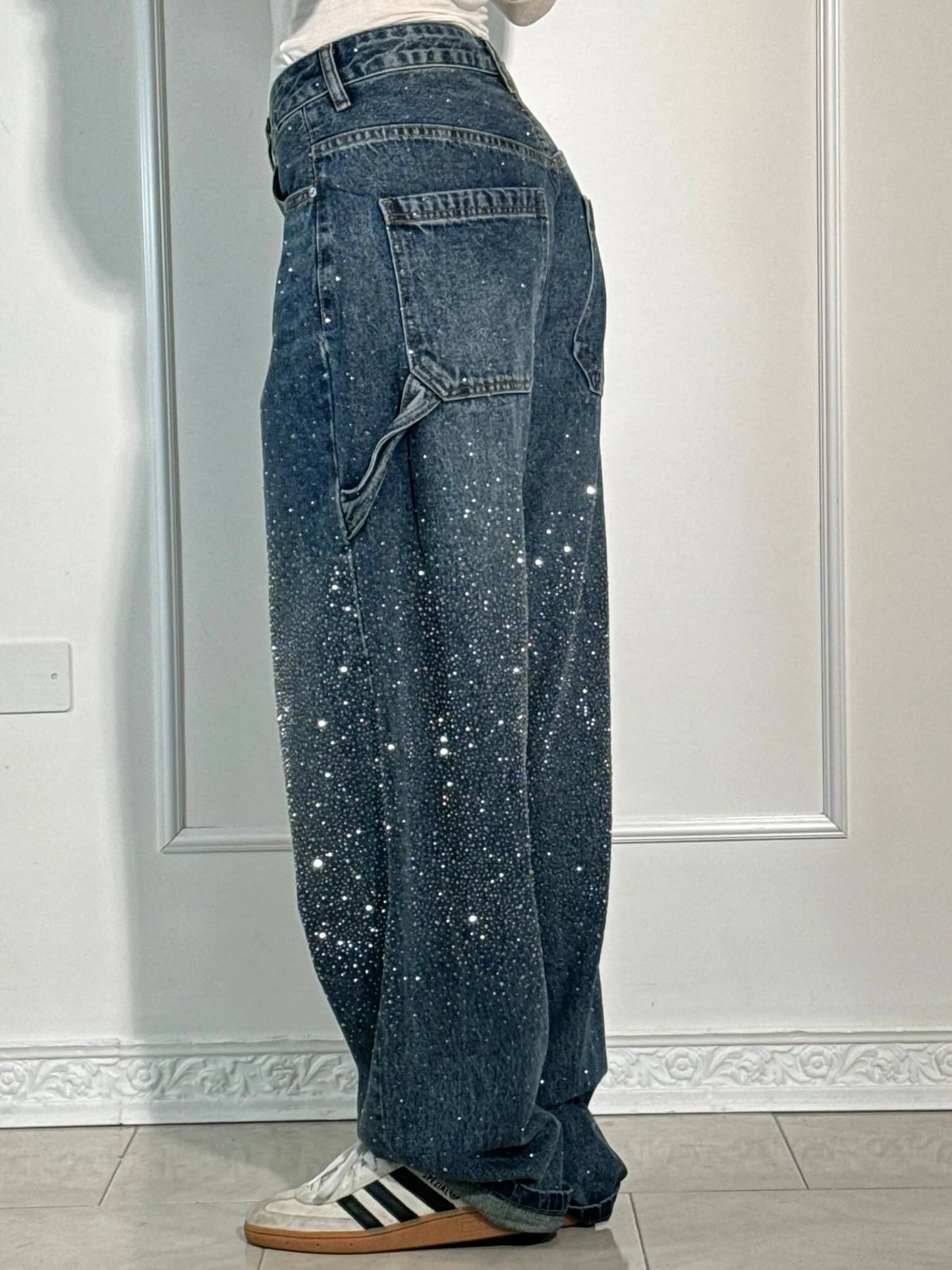 "Jeans donna baggy, dettagli brillanti, denim blu scuro, gambe larghe, chiusura zip e bottone, look casual ed elegante."
