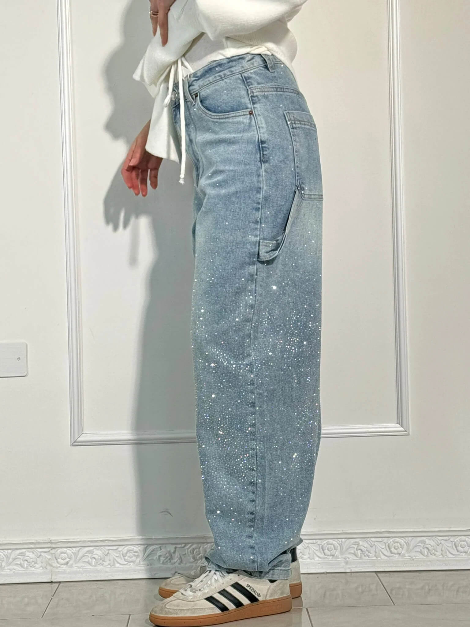 "Jeans donna baggy, dettagli brillanti, denim blu scuro, gambe larghe, chiusura zip e bottone, look casual ed elegante."