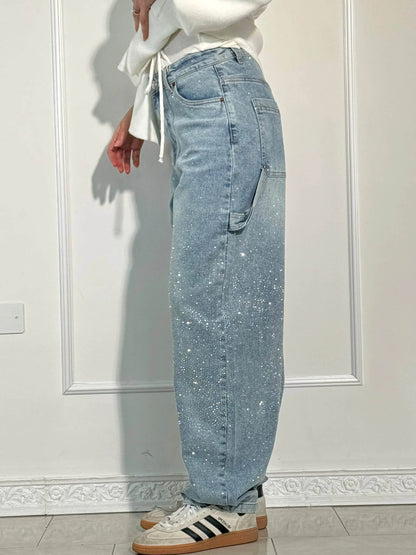 "Jeans donna baggy, dettagli brillanti, denim blu scuro, gambe larghe, chiusura zip e bottone, look casual ed elegante."