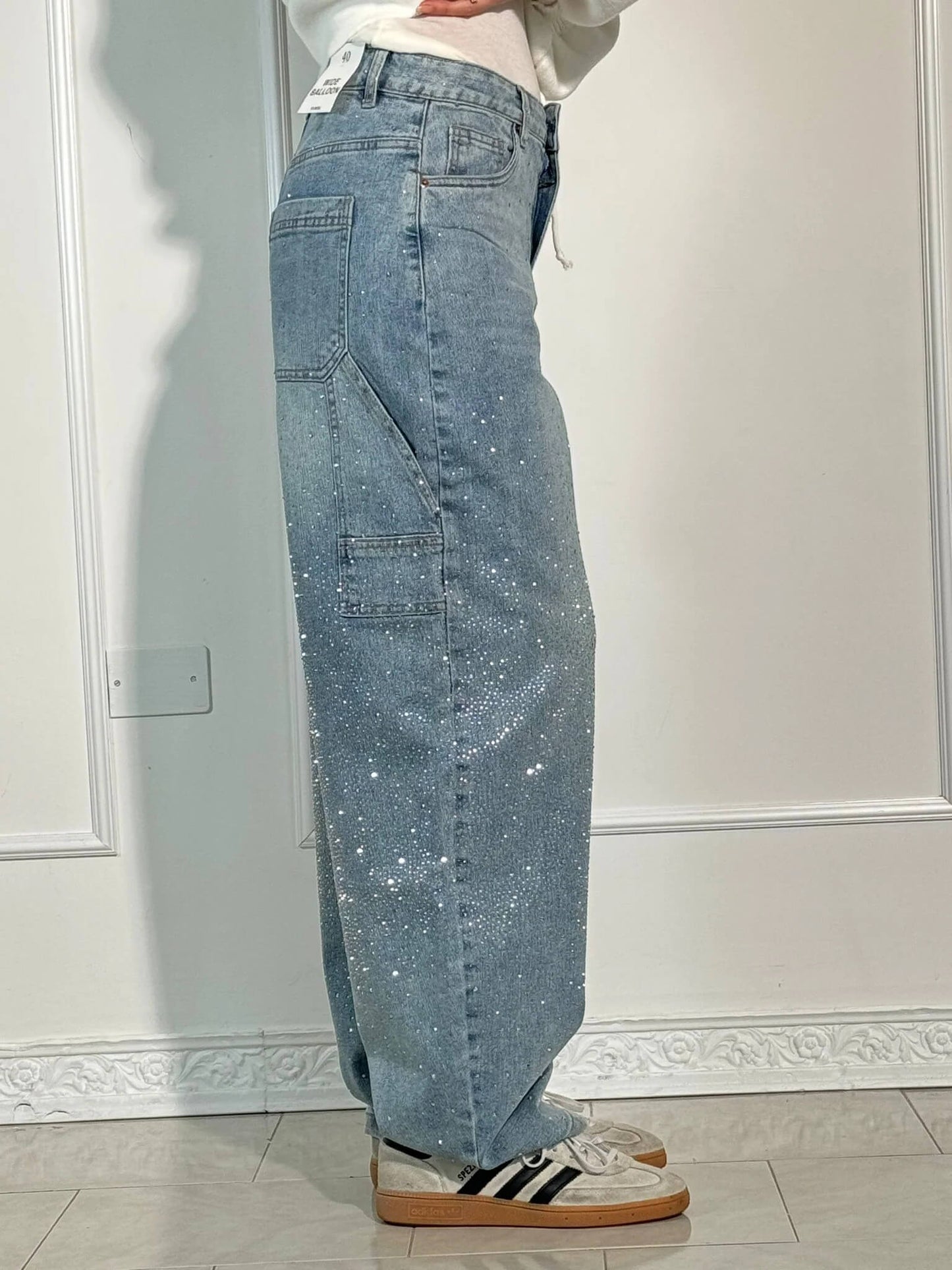 "Jeans donna baggy, dettagli brillanti, denim blu scuro, gambe larghe, chiusura zip e bottone, look casual ed elegante."
