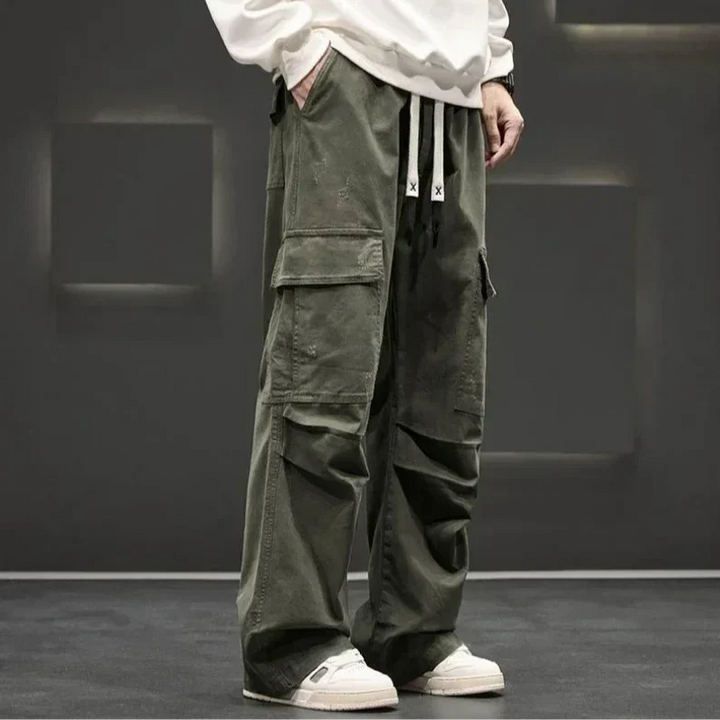 Men's relaxed fit utility cargo pants showcasing multi-pocket design & comfortable drawstring waist for versatile outdoor use.