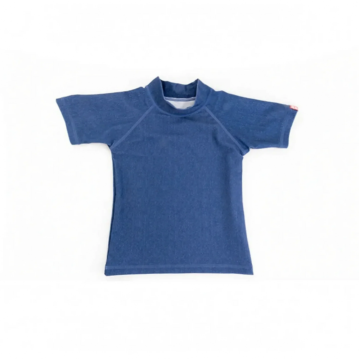 Kid wearing a short-sleeve UPF 50+ rash guard, enjoying sun-protected play at the beach.