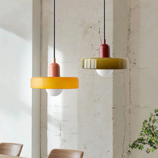 "Lampada a sospensione in vetro trasparente con design minimalista, emette luce soffusa, ideale per interni eleganti."