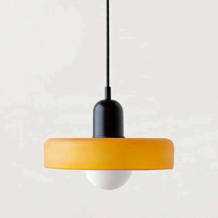 "Lampada a sospensione in vetro trasparente con design minimalista, emette luce soffusa, ideale per interni eleganti."
