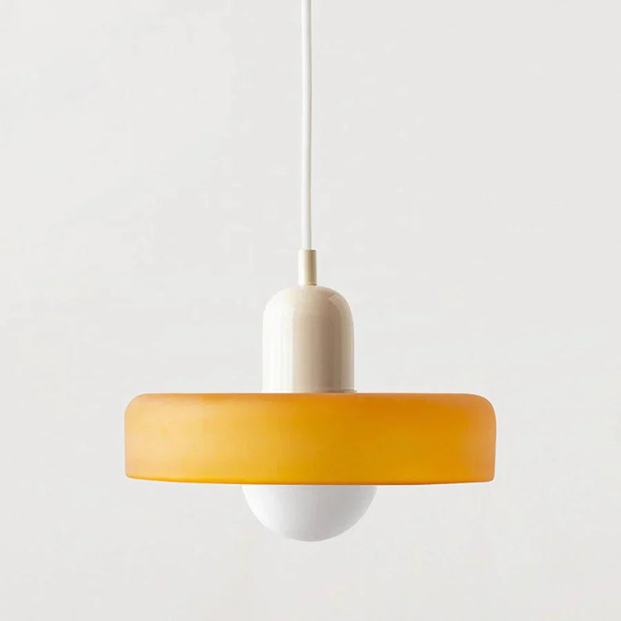 "Lampada a sospensione in vetro trasparente con design minimalista, emette luce soffusa, ideale per interni eleganti."