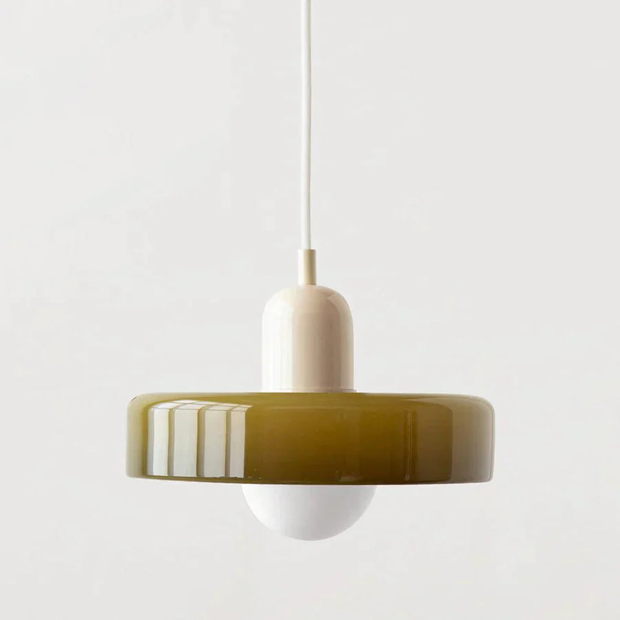 "Lampada a sospensione in vetro trasparente con design minimalista, emette luce soffusa, ideale per interni eleganti."