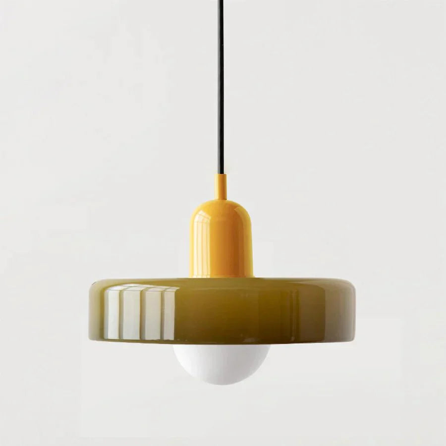 "Lampada a sospensione in vetro trasparente con design minimalista, emette luce soffusa, ideale per interni eleganti."