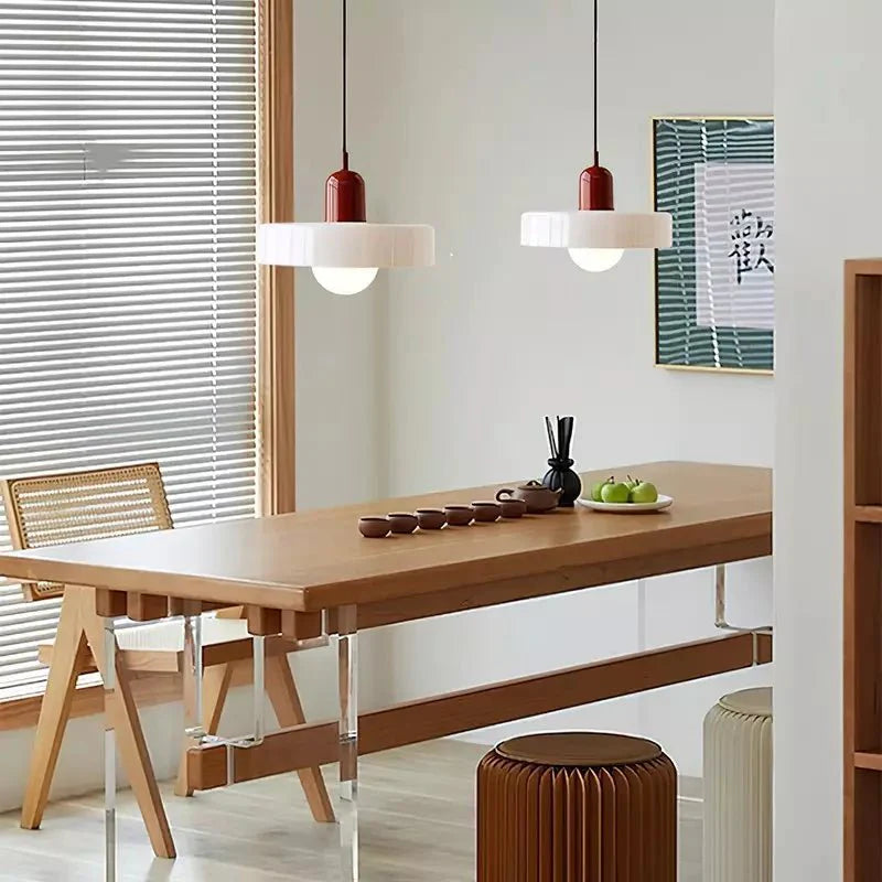 "Lampada a sospensione in vetro trasparente con design minimalista, emette luce soffusa, ideale per interni eleganti."