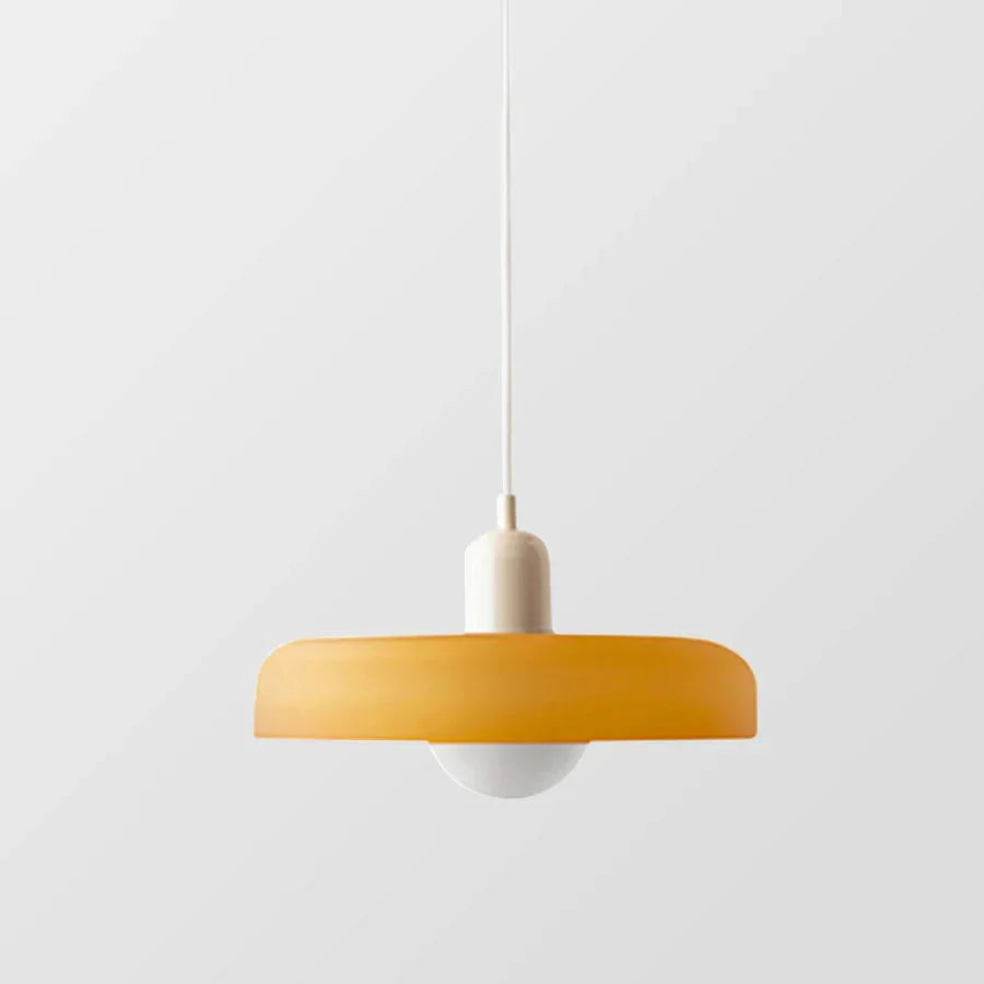 "Lampada a sospensione in vetro trasparente con design minimalista, emette luce soffusa, ideale per interni eleganti."