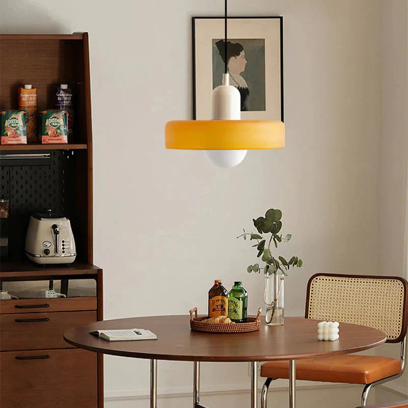 "Lampada a sospensione in vetro trasparente con design minimalista, emette luce soffusa, ideale per interni eleganti."