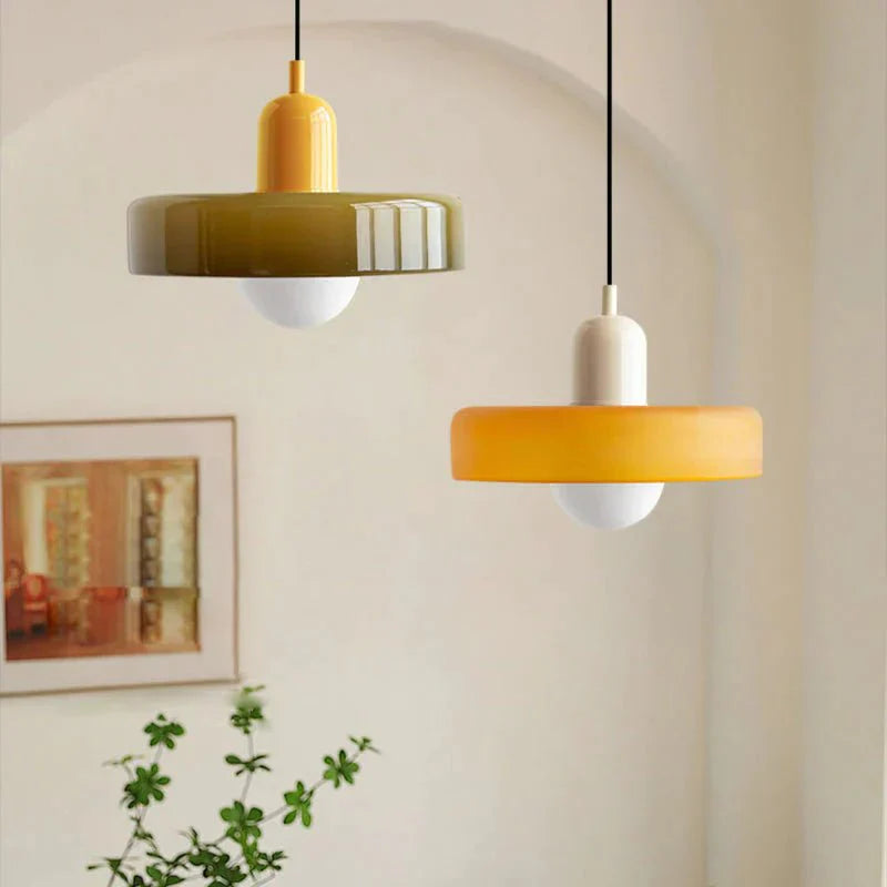 "Lampada a sospensione in vetro trasparente con design minimalista, emette luce soffusa, ideale per interni eleganti."