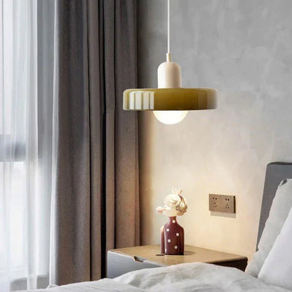 "Lampada a sospensione in vetro trasparente con design minimalista, emette luce soffusa, ideale per interni eleganti."