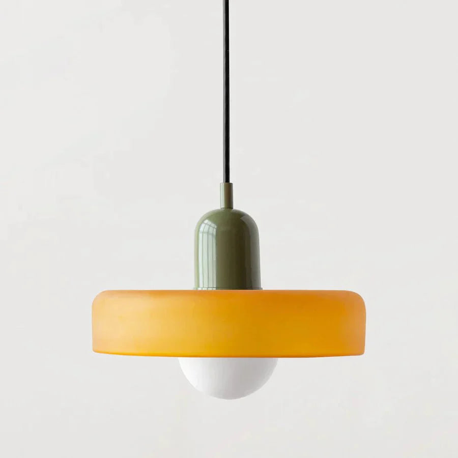 "Lampada a sospensione in vetro trasparente con design minimalista, emette luce soffusa, ideale per interni eleganti."