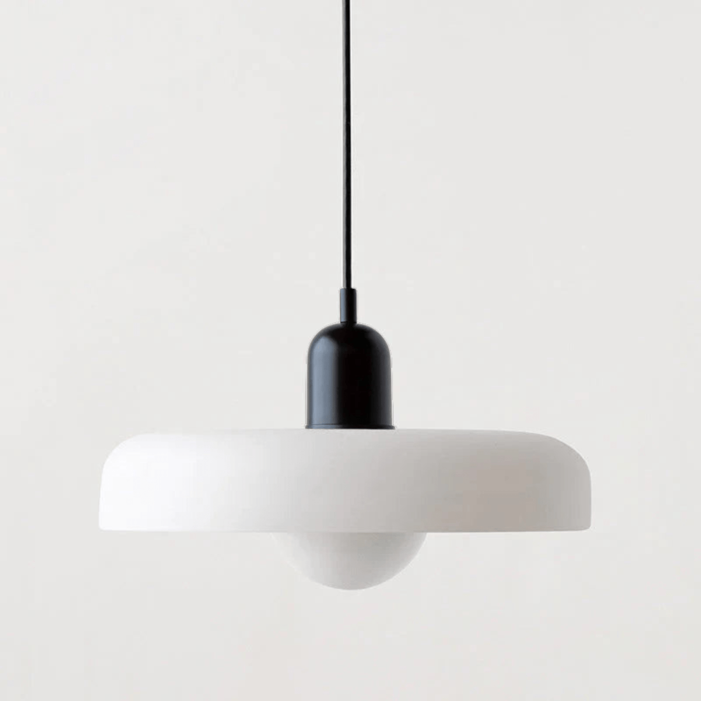 "Lampada a sospensione in vetro trasparente con design minimalista, emette luce soffusa, ideale per interni eleganti."
