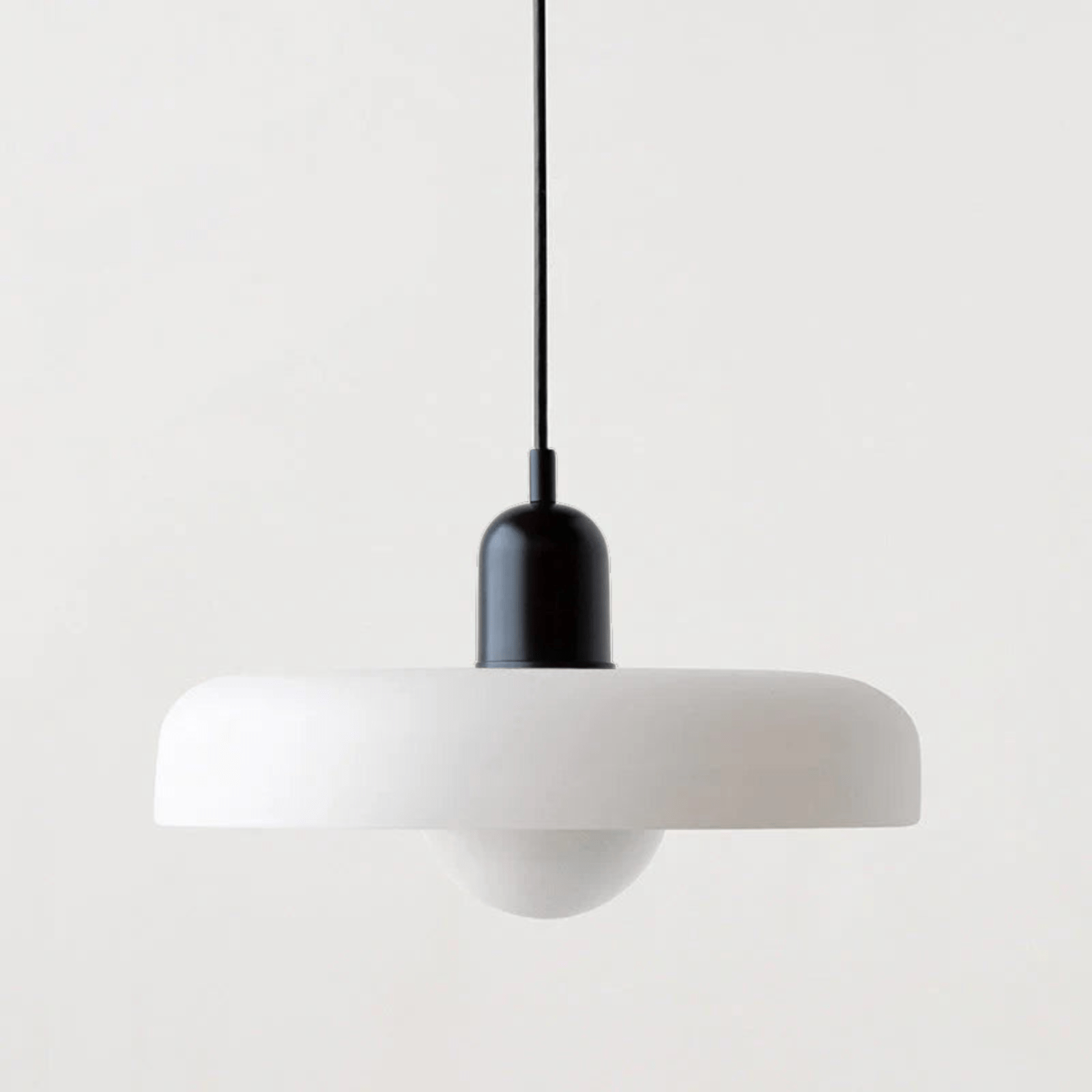 "Lampada a sospensione in vetro trasparente con design minimalista, emette luce soffusa, ideale per interni eleganti."