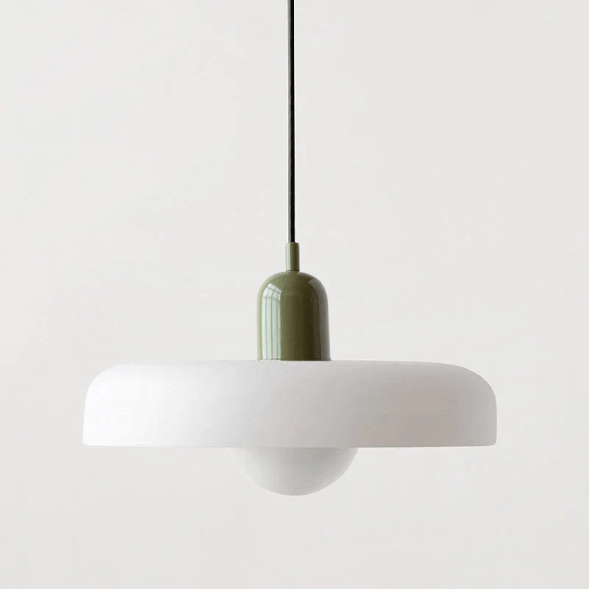 "Lampada a sospensione in vetro trasparente con design minimalista, emette luce soffusa, ideale per interni eleganti."