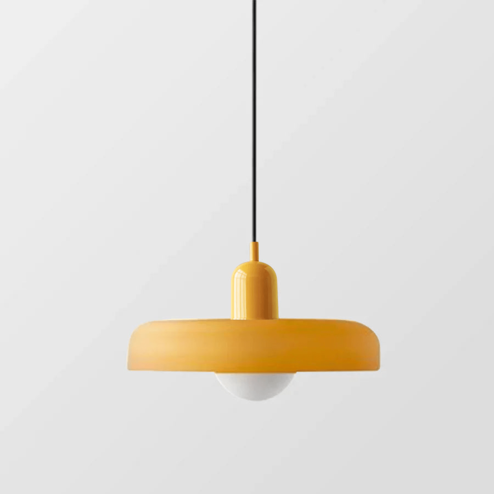 "Lampada a sospensione in vetro trasparente con design minimalista, emette luce soffusa, ideale per interni eleganti."