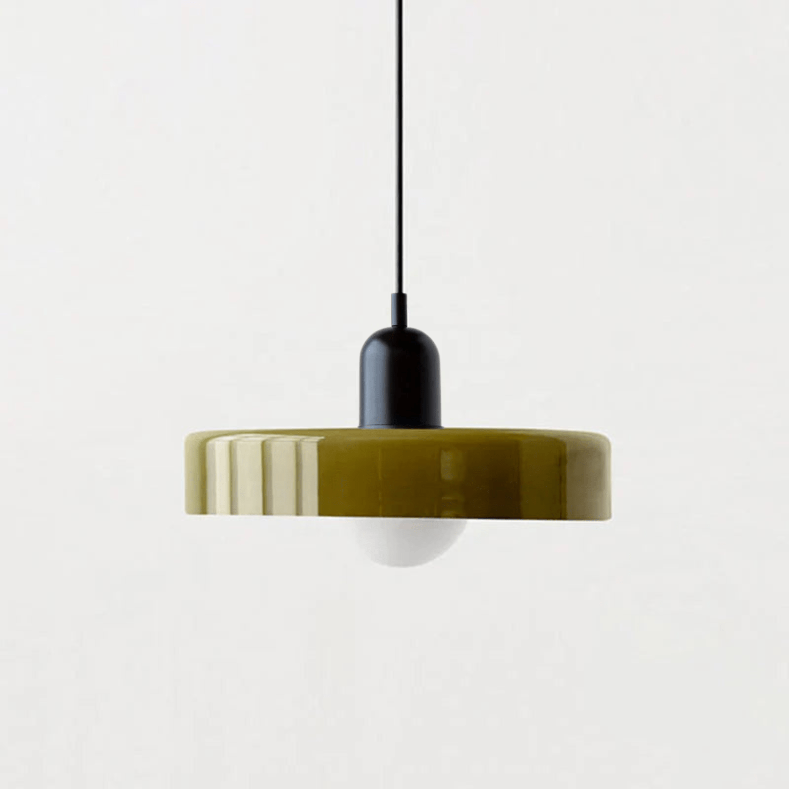 "Lampada a sospensione in vetro trasparente con design minimalista, emette luce soffusa, ideale per interni eleganti."