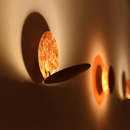 "Lampada da parete design eclisse, luce soffusa calda, metallo resistente, per atmosfera accogliente in soggiorno o camera."