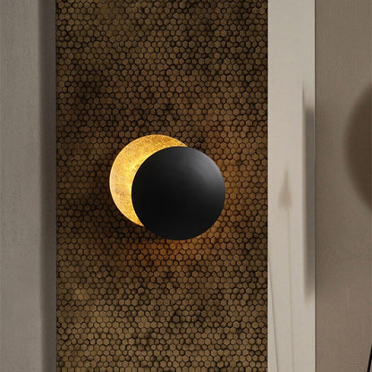 "Lampada da parete design eclisse, luce soffusa calda, metallo resistente, per atmosfera accogliente in soggiorno o camera."