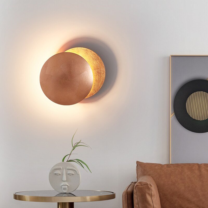 "Lampada da parete design eclisse, luce soffusa calda, metallo resistente, per atmosfera accogliente in soggiorno o camera."