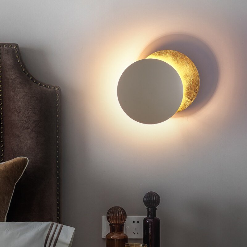 "Lampada da parete design eclisse, luce soffusa calda, metallo resistente, per atmosfera accogliente in soggiorno o camera."