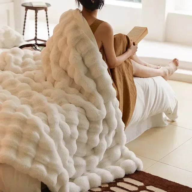 Cozy faux fur throw blanket draped stylishly on a sofa, providing plush comfort and warmth.