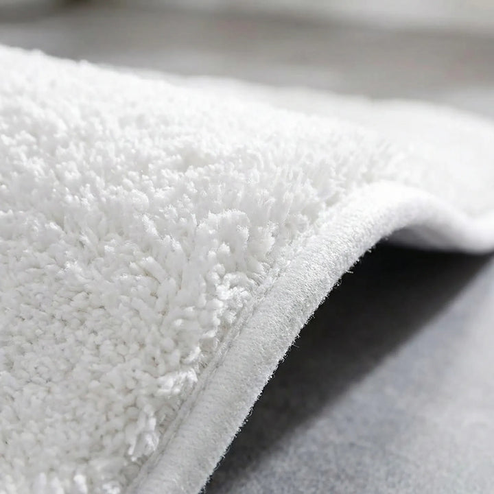 Absorbent, washable luxury bath mat by Flowique. Thick, plush texture for superior home comfort & hygiene.
