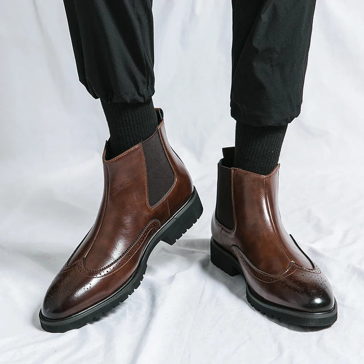 Men's black Chelsea boots, featuring a brogue design for a smart casual or dressy appearance.