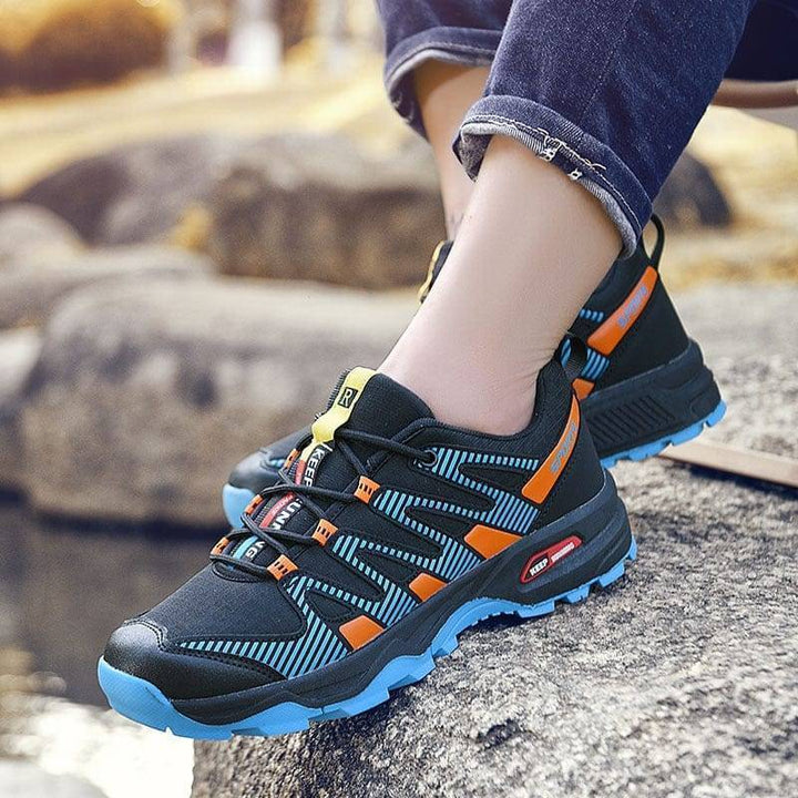 Close-up of men's hiking footwear, showing breathable mesh and sturdy sole for trails.