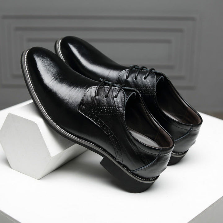 Men's black Oxford dress shoes worn with business attire, showcasing a polished, professional look.