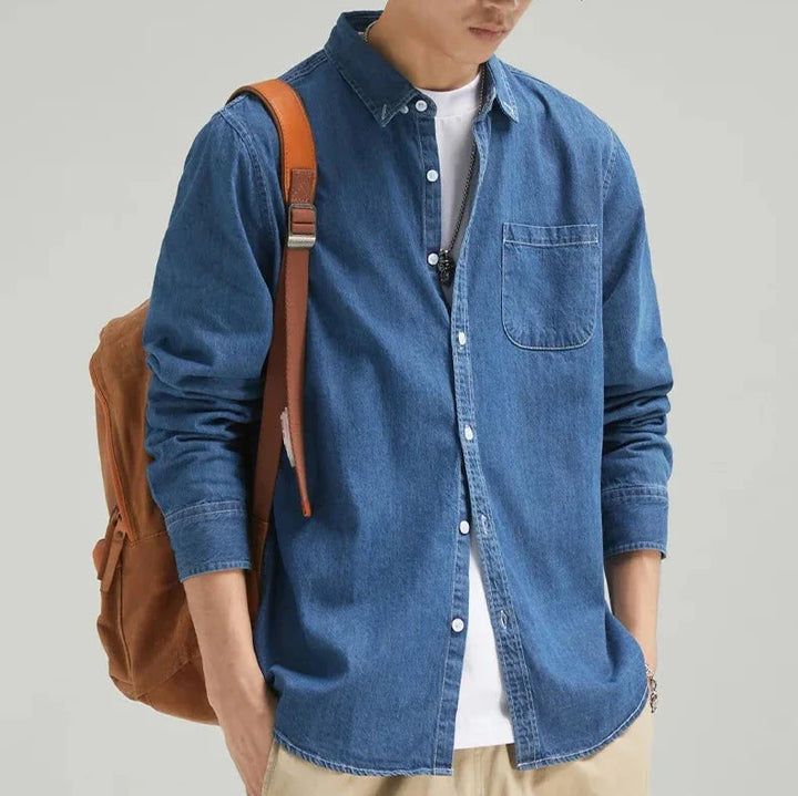 Classic blue denim men's shirt. Long sleeve button-up offers durable material and timeless casual style.