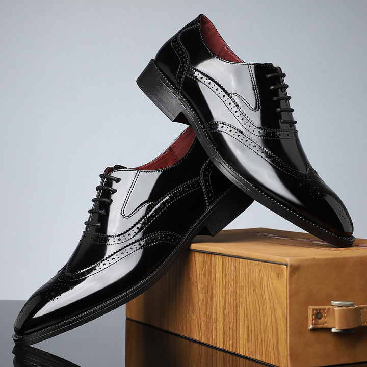Detailed close-up of men's classic brogue wingtip dress shoes, showcasing polished leather & craftsmanship.