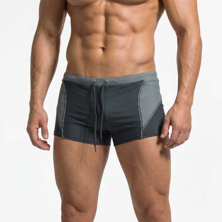 Vibrant color block men's boxer swim trunks for a sporty look. Quick-dry, secure fit beachwear.