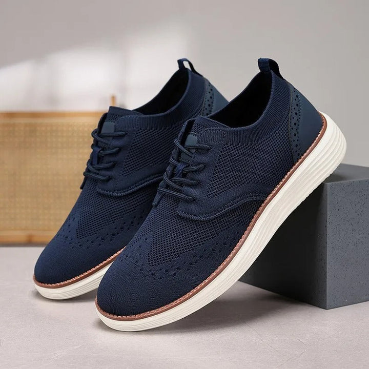 Close-up of wingtip detail on men's comfort dress sneakers. Breathable, casual formal footwear.