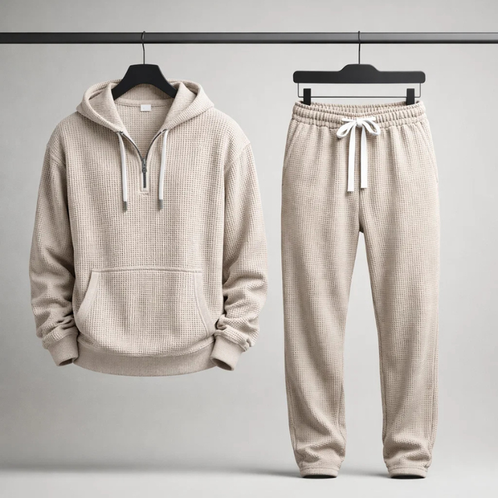 Man modeling a grey textured men's lounge set, featuring a relaxed-fit hoodie & drawstring joggers.
